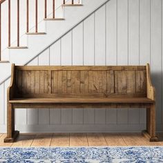 a wooden bench sitting in front of a stair case