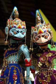 two figurines are dressed in colorful costumes