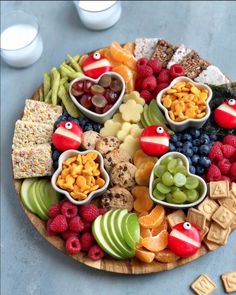 a platter filled with fruit, crackers and cheeses on top of a table