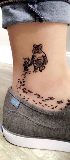 a woman's stomach with a small bear tattoo on her lower leg and foot