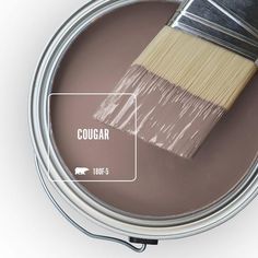 a paint can with a brush in it and labeled cougar on the side