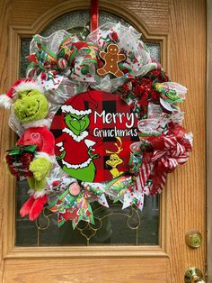 a christmas wreath on the front door is decorated with candy canes and teddy bears