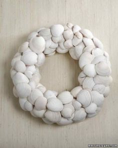 a close up of a wreath made out of shells on a wooden surface with text overlay that reads, how to make a seashell wreath