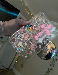 someone is holding up a clear case with stickers and teddy bears on it in front of a mirror