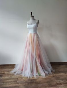 a dress on a mannequin stand in front of a white wall and wooden floor