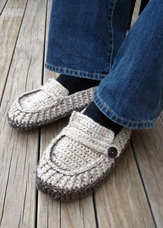 someone is wearing crocheted slippers with buttons on the bottom and one foot