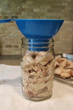 a glass jar filled with food sitting on top of a table next to a metal pan