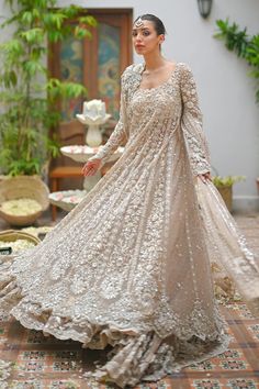 a woman in a long dress standing on a tiled floor