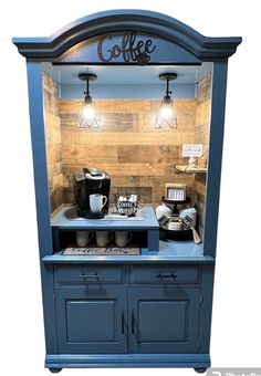 an old fashioned coffee shop with blue cabinets and lights on the top shelf is shown