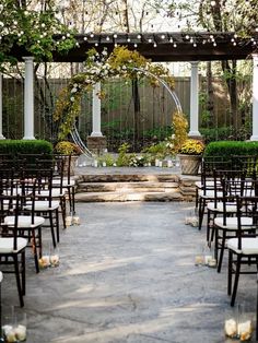 an outdoor ceremony set up with chairs and candles