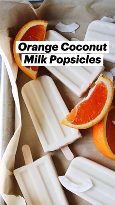 popsicles with orange slices cut in half and on top of each other, sitting on wax paper