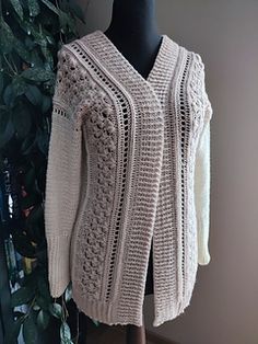 a white knitted sweater sitting on top of a mannequin