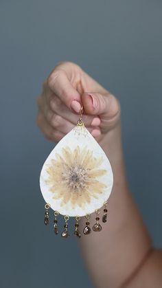 White teardrop shaped earrings with pressed flower focal points and Czech glass drops created using a silk fusion technique Bohemian Pressed Flowers Drop Earrings, Bohemian Dangle Earrings With Pressed Flowers, Bohemian Drop Earrings With Pressed Flowers, Bohemian Pressed Flower Earrings, Bohemian Flower Earrings With Pressed Flowers, Handmade White Flower Earrings Nature-inspired, Handmade White Nature-inspired Flower Earrings, Handmade White Botanical Earrings, White Nature-inspired Earrings With Birth Flower