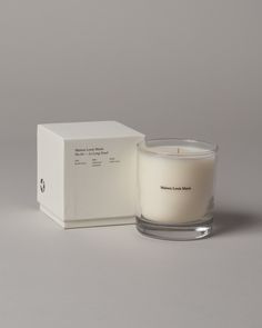 a white candle sitting in front of a box