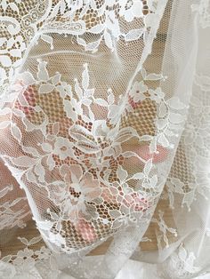 the lace is white and has pink flowers on it