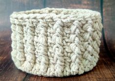 a white crochet basket sitting on top of a wooden table