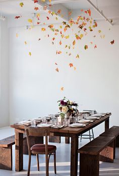 the table is set with plates and glasses on it, while butterflies are flying from the ceiling