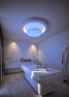 a modern bathroom with white furniture and lights on the ceiling is lit by recessed lighting