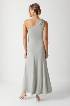 a woman wearing a grey dress with one shoulder