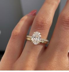 a woman's hand with a diamond ring on top of her finger and an engagement band