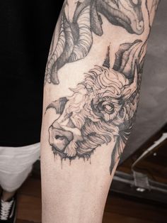 a man's leg with tattoos on it and an animal head in the middle