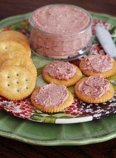 some crackers are on a plate with pink dip