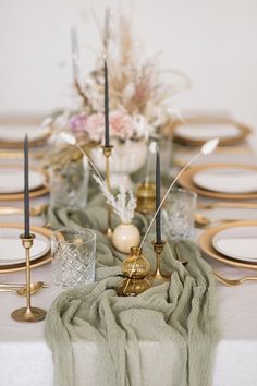 the table is set with candles, plates, and napkins for an elegant dinner