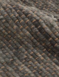 close up view of the texture of a wool and tweed fabric, with orange stripes