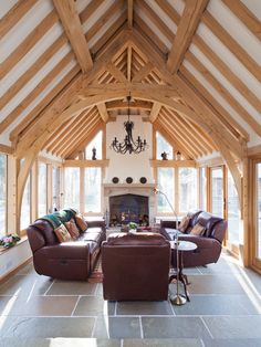 a living room filled with furniture and a fire place in the middle of an open floor plan