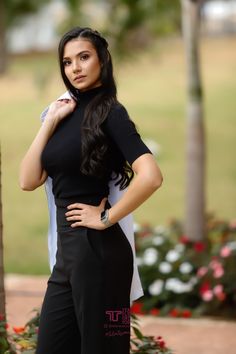 a woman in black and white poses for the camera with her hands on her hips