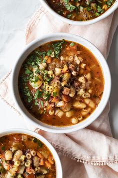 two white bowls filled with soup on top of a table