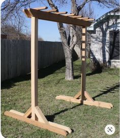 a wooden structure sitting in the grass near a tree