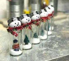 there are snowmen in glass jars on the table