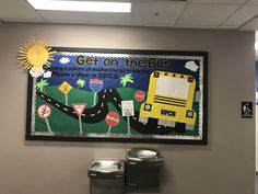 a school bus is painted on the wall above two trash cans and a garbage can