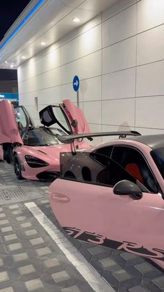 several pink sports cars parked next to each other