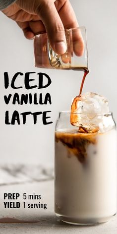 iced vanilla latte being poured into a glass with ice and caramel on top