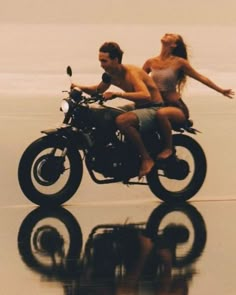 a man and woman riding on the back of a motorcycle