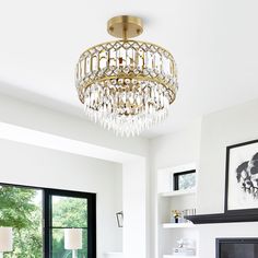 a living room filled with furniture and a chandelier hanging from the ceiling over a fire place