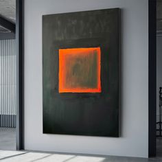 an abstract painting hangs in the corner of a room