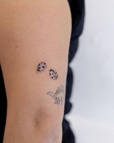 a ladybug tattoo on the left arm and right arm with two ladybugs