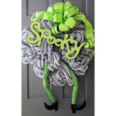 a green and white wreath with the word spooky hanging on it's front door