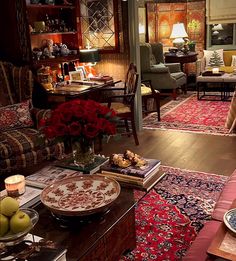 a living room filled with lots of furniture and flowers on top of a coffee table