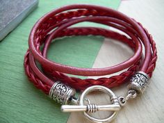 A Metallic Red Leather Bracelet.... Super stylish and feminine, wrap this twice around your wrist, toggle up and off you go. This Double Wrap Leather Bracelet features 3mm round, 3mm braided and 5mm flat braided metallic leather cords. Lead and Nickel Free - Aged Silver Toned Alloy Components, Secure Toggle Closure for Easy on and off. All dyes used in our leather are certified 100% Lead-Free and meet all requirements of the German Goods Ordinance, REACH (European Union), RoSH (U.K.), and CPSIA Handmade Red Wrap Bracelet, Adjustable Burgundy Bracelets, Trendy Red Adjustable Leather Bracelet, Red Leather Bracelet, Leather Bracelets Women, Toggle Bracelet, Leather Bracelets, Unique Jewelry Designs, Leather Wrap Bracelet