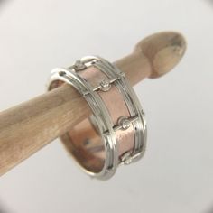 a close up of a ring on a wooden stick in front of a white background