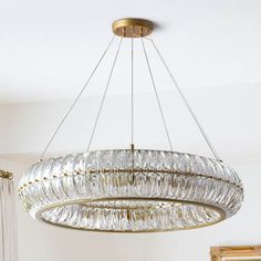 a chandelier hanging from the ceiling in a room with white walls and curtains