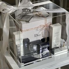 a clear box filled with different types of perfumes on top of a glass table