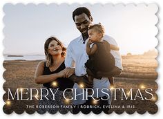 a merry christmas card with an image of a man and woman holding a small child