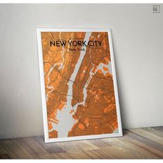 the new york city map is shown in an orange and white frame on a wooden floor