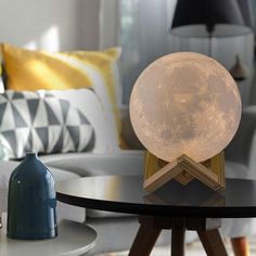 the moon lamp is sitting on top of a table in front of a couch and chair