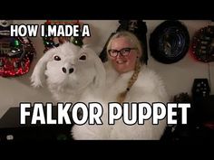 a woman standing next to a white dog in front of a wall covered with christmas decorations